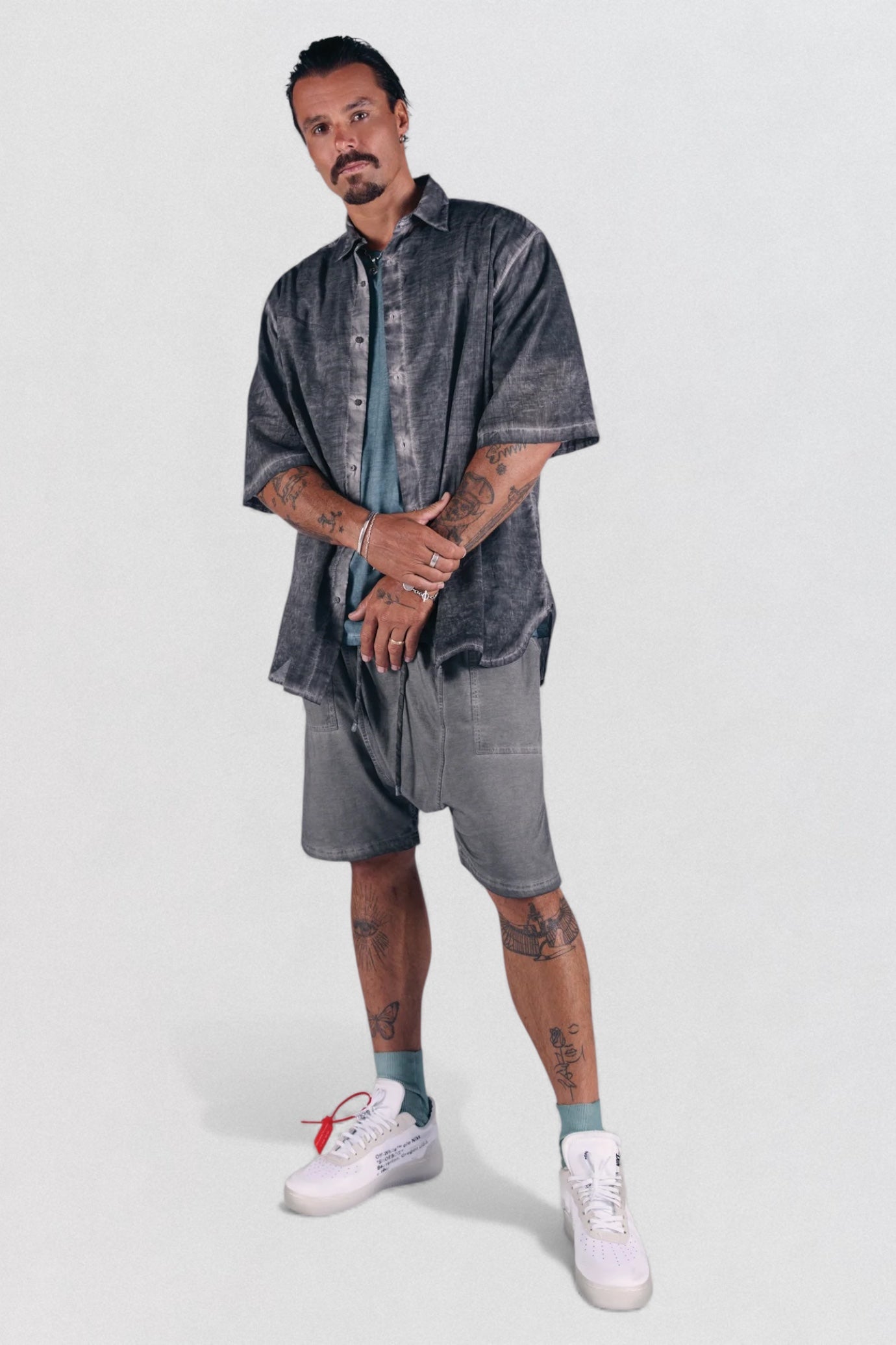 DESU Drop Crotch Shorts. Man wearing a denim outfit with shorts and sneakers on a white background