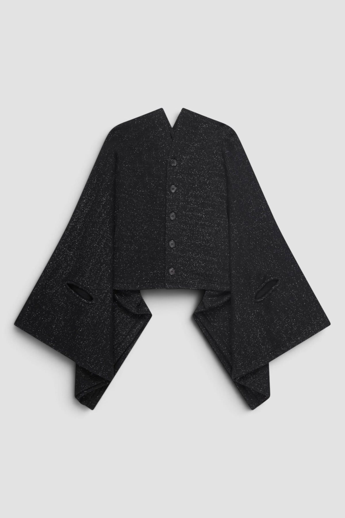 Junya Watanabe Glitter Cape Cardigan in Black with draped cape silhouette, cut out armholes, front button closure, and glitter fabric