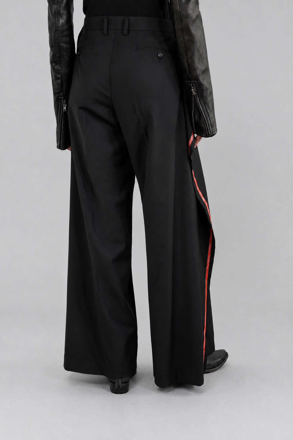 Junya Watanabe SS26 Side Stripes Trousers. Black wide-leg pants with red stripes on a gray background