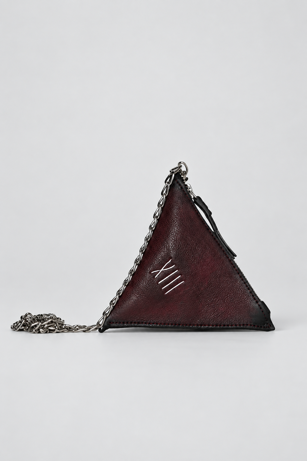 NUTSA NM9901 Leather Charm Pouch in burgundy black calf leather with triangular shape, detachable metal chain, and zipper closure