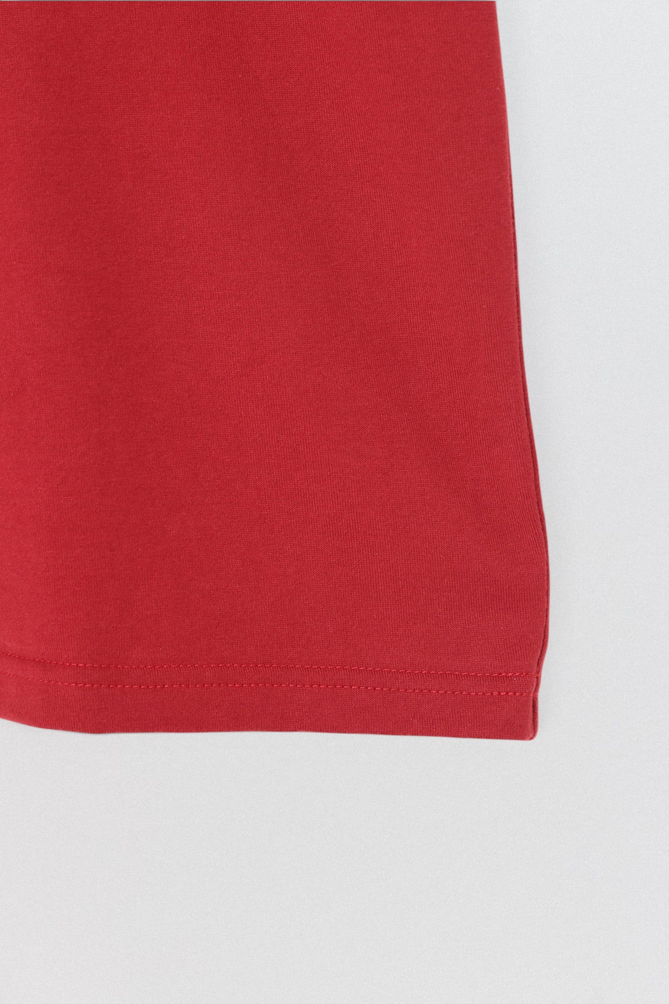 Undercover SS26 Bike Man T-Shirt Close-up of a red fabric corner on a white background