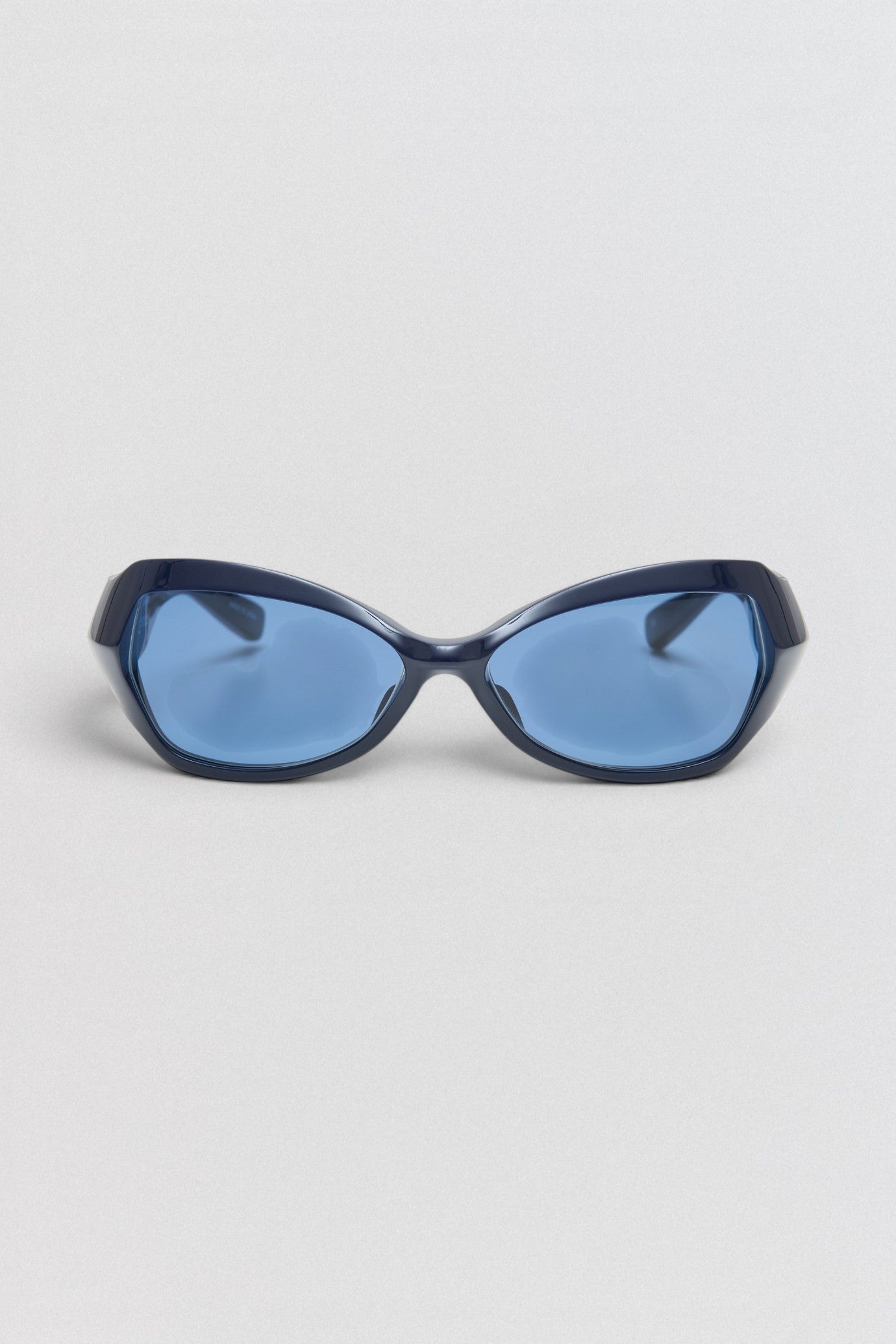 Undercover SS26 Factory900  Blue sunglasses on a light gray background