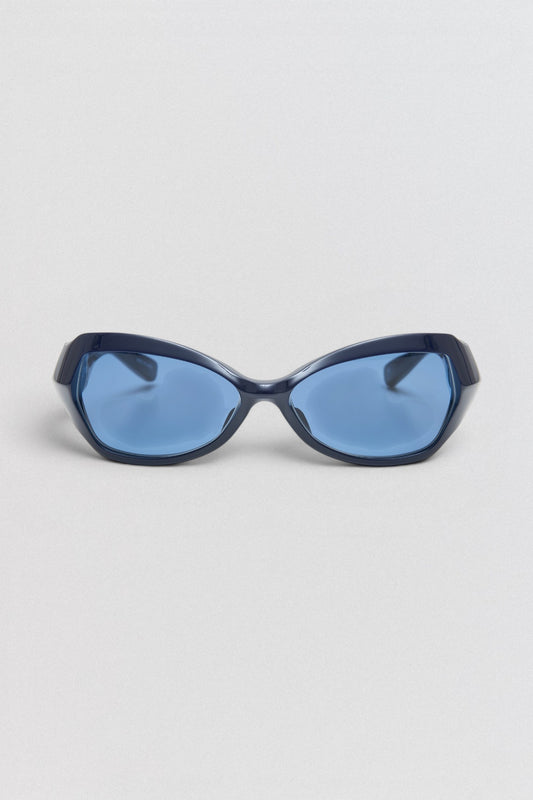 Undercover SS26 Factory900  Blue sunglasses on a light gray background