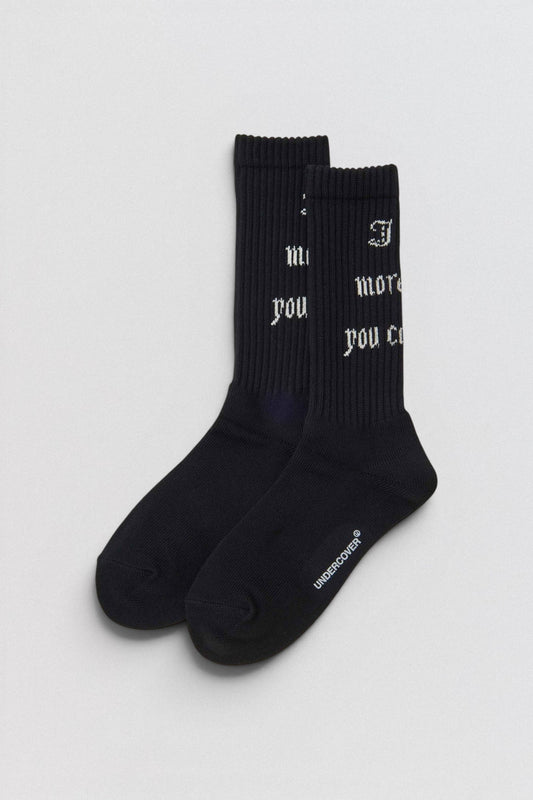 Undercover SS26 Logo  Pair of black socks on a white background