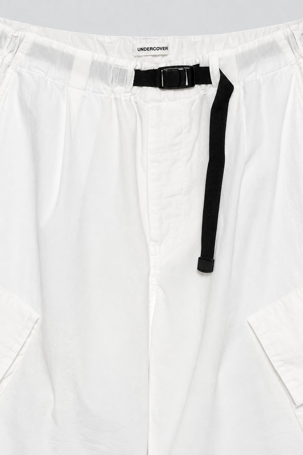 UNDERCOVER Belted Cargo Shorts in white cotton woven fabric with black built in belt, cargo pockets, and CHAOS BALANCE embroidery
