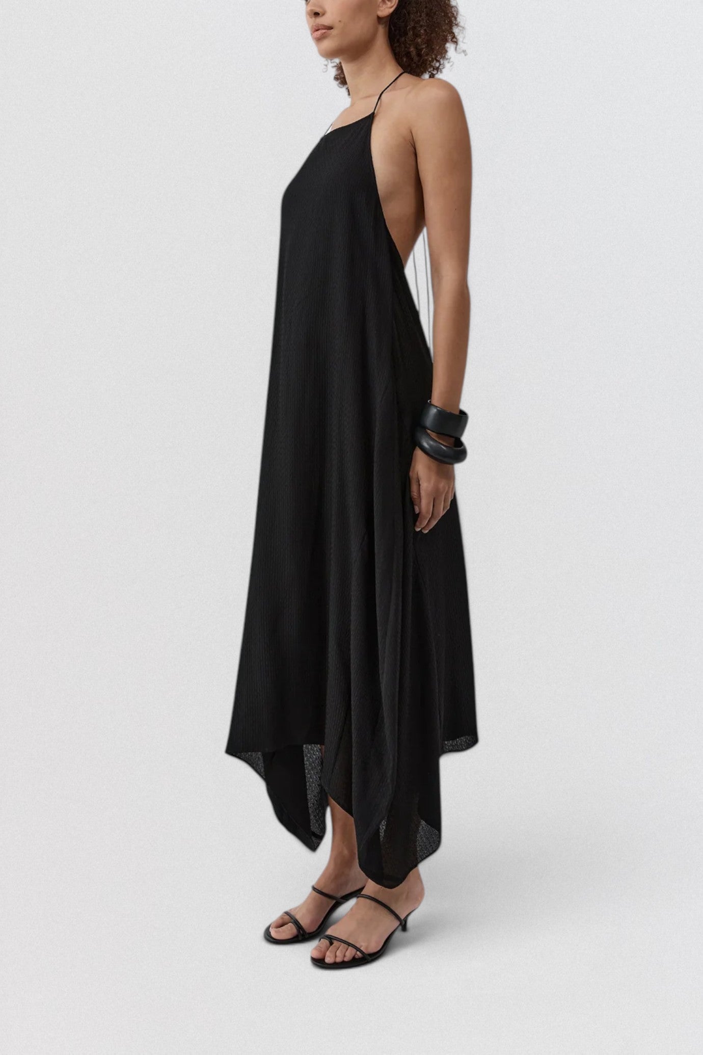 ST. AGNI Textured Weave Halter Dress in black with square halter neckline and asymmetric handkerchief hem