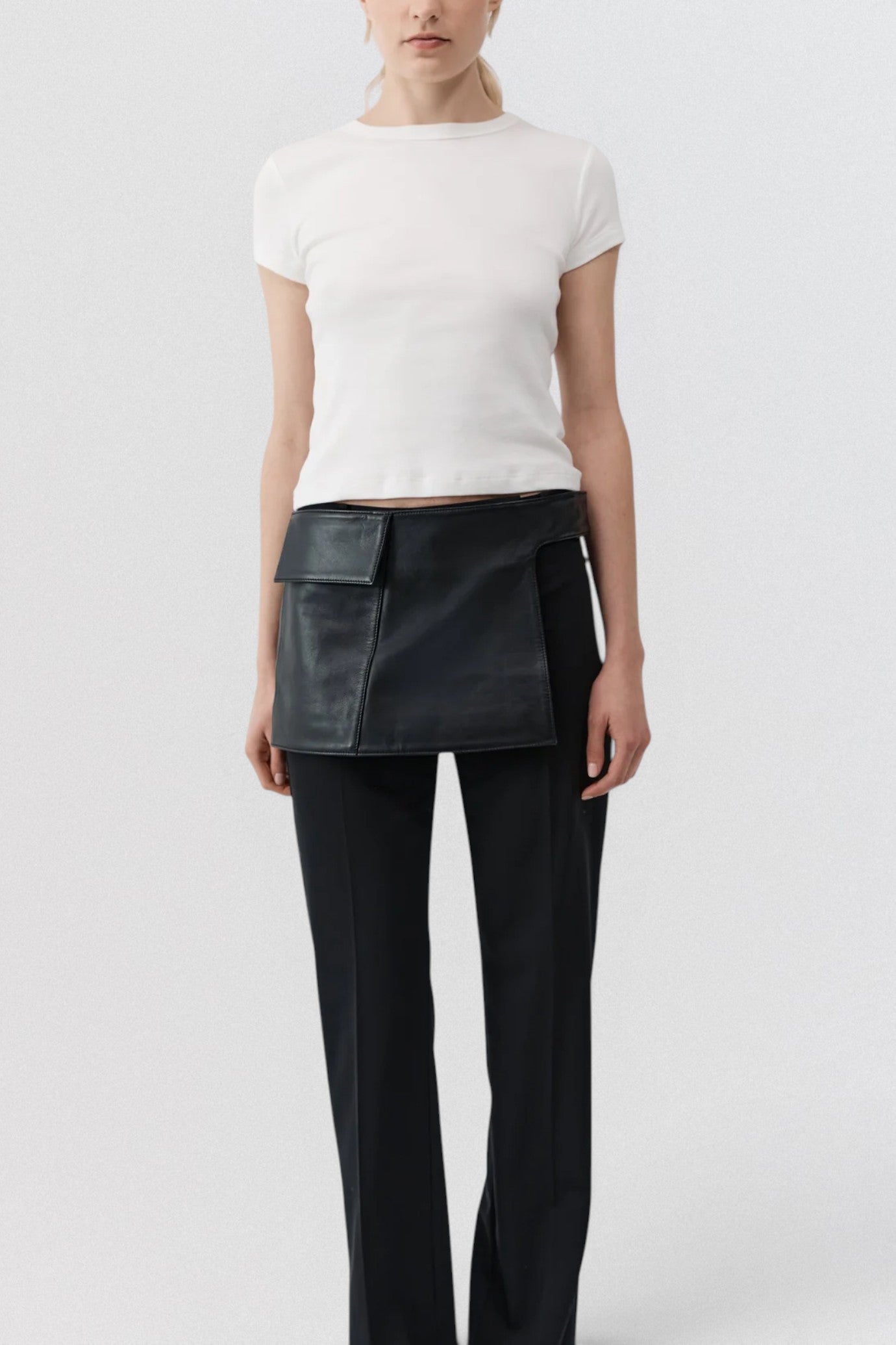 ST. AGNI Utility Skirt Belt in black lambskin leather with fold-over waistband and side cut-out detail
